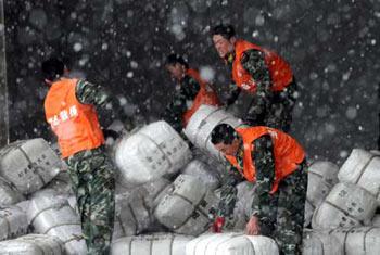 Soldiers of the armed police force carry disaster-relief resources in Wuhan, capital of central China's Hubei Province, Feb. 1, 2008. Some 120,000 clothes and quilts were sent to people suffering from severe snowstorm and frost in Hubei province on Friday. (Xinhua Photo)
