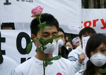 A man holds a rose and joins thousands of Chinese students and expatriates in a rally at Old Palace Yard in London on April 19, 2008, to protest against the BBC's and other British news organizations' distorted and lopsided reports on Tibetan secessionist violence and London leg of Olympics torch relay. [Lei Xiaoxun/chinadaily.com.cn]