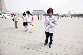 Tourists mourn while visiting Ti'anmen Square in Beijing, capital of China, May 19, 2008. Millions of people in China and overseas observed three minutes silence at 2:28 p.m. Monday to mourn thousands of people killed in an earthquake which hit southwest China's Sichuan province a week ago. Across the country, air raid sirens, cars, trains and ship horns wailed in grief as the people fell silent. (Xinhua/Cai Yang) 