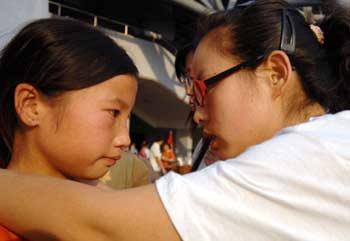 A psychologist consoles a girl who experienced last Monday's earthquake in southwest China's Sichuan Province May 19, in Mianyang, Sichuan. According to experts sent by the All-China Women's Federation to help children in quake-affected areas, extra care is needed to help these children.(Xinhua Photo)
