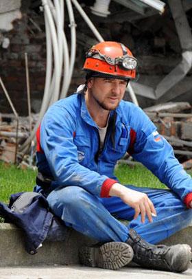 A member of Russian rescue team rests near the debris in the quake-hit Sichuan Province in southwest China, May 18, 2008. (Xinhua Photo)