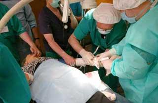 Russian surgeons conduct operation for the quake-injured 77-year-old Huang Wenfeng in the inflatable surgery room, at Pengzhou, southwest China's Sichuan Province, May 21, 2008. The Russian medical team carried out surgical operations at the inflatable mobile hospital, comprising surgery rooms, patients' ward and other relevant facilities on Wednesday morning. (Xinhua Photo)