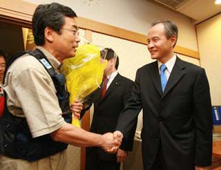 Chinese Ambassador to Japan Cui Tiankai(R) shakes hands with the captain of the Japanese medical team at the Narita airport in Chiba Prefecture, Japan, June 2, 2008. (Xinhua Photo)