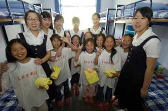 Students from the quake-hit Sichuan Province in southwest China pose for a photo with volunteers in their dormitory in Jinan, capital of east China's Shandong Province, June 5, 2008.(Xinhua Photo)