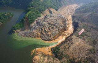 Picture taken on June 10, 2008 from a military helicopter shows the drainage of the Tangjiashan quake lake in southewest China's Sichuan Province. Drainage of the quake lake through a manmade spillway speeded up to 1,760 cubic meters per second at 9:30 am on Tuesday, whereas water flow in the lower reaches of the lake, in Beichuan County, reached 2,240 cubic meters per second.(Xinhua/Li Gang)