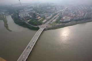 Picture taken on June 10, 2008 from a military helicopter shows floodwater flowing beneath the Dongfanghong bridge of Mianyang city in southewest China's Sichuan Province. Drainage of the quake lake through a manmade spillway speeded up to 1,760 cubic meters per second at 9:30 am on Tuesday, whereas water flow in the lower reaches of the lake, in Beichuan County, reached 2,240 cubic meters per second.(Xinhua/Li Gang)