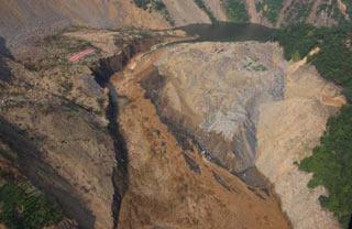 Picture taken on June 10, 2008 from a military helicopter shows the drainage of the Tangjiashan quake lake in southewest China's Sichuan Province. Drainage of the quake lake through a manmade spillway speeded up to 1,760 cubic meters per second at 9:30 am on Tuesday, whereas water flow in the lower reaches of the lake, in Beichuan County, reached 2,240 cubic meters per second.(Xinhua/Li Gang)
