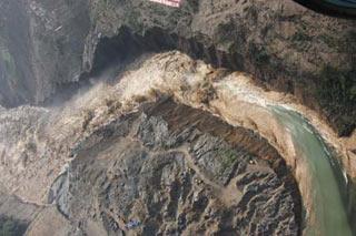 Picture taken at 9 a.m. of June 10, 2008 from a military helicopter shows the water gushed out of the Tangjiashan quake lake in southewest China's Sichuan Province. Drainage of the quake lake through a manmade spillway speeded up to 1,760 cubic meters per second at 9:30 am on Tuesday, whereas water flow in the lower reaches of the lake, in Beichuan County, reached 2,240 cubic meters per second. (Xinhua/Li Gang)