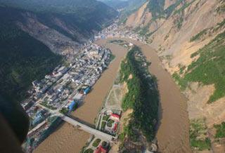 Picture taken on June 10, 2008 from a military helicopter shows flood water flowing past Beichuan County in southewest China's Sichuan Province. Drainage of the Tangjiashan quake lake through a manmade spillway speeded up to 1,760 cubic meters per second at 9:30 am on Tuesday, whereas water flow in the lower reaches of the lake, in Beichuan County, reached 2,240 cubic meters per second. (Xinhua/Li Gang)