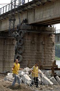 Workers are busy in the protection of Fujiang Bridge on the railway from Baoji, a city of northwest China's Shaanxi Province, to Chengdu, in Mianyang city, southwest China's Sichuan Province, June 10, 2008.  (Xinhua Photo)