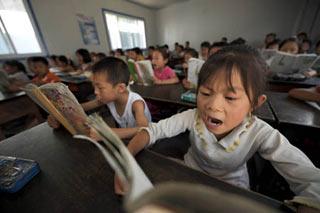 Second graders attend class in a temporary classroom at Chengguan No.2 elementary school in Wenxian county, Longnan city, northwest China's Gansu Province June 11, 2008. About 90 percent of the 2,964 middle schools and elementary schools suspended in the quake-hit Longnan city have resumed classes by now. The local government is still working hard to help reopen schools and kindergartens in remote villages and mountainous areas.(Xinhua Photo)