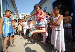 Third graders play games during a break at Chengguan No.2 elementary school in Wenxian county, Longnan city, northwest China's Gansu Province June 11, 2008. About 90 percent of the 2,964 middle schools and elementary schools suspended in the quake-hit Longnan city have resumed classes by now. The local government is still working hard to help reopen schools and kindergartens in remote villages and mountainous areas. (Xinhua Photo)