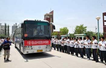 Buses carrying high school students from quake-affected Qingchuan County of southwest China's Sichuan Province are welcomed as they arrive at Liupanshan Higher Middle School in Yinchuan, capital of northwest China's Ningxia Hui Autonomous Region, on June 12, 2008. A total of 130 high shool students from Qingchuan will continue their studies at Ningxia Liupanshan Higher Middle School. Their school tuitions and daily costs are covered by the government of Ningxia Hui Autonomous Region.(Xinhua Photo)