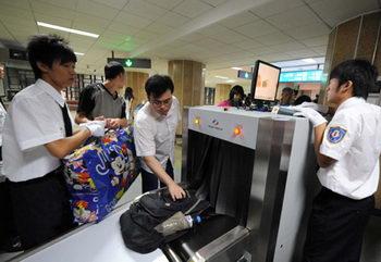 Passengers (2nd, 3rd L) receive security check at a subway station in downtown Beijing, China, June 29, 2008. (Xinhua Photo)