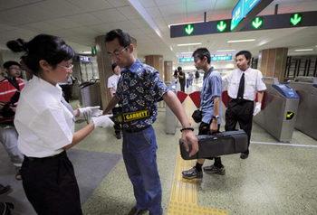 Passengers receive security check at the Andingmen Subway Station in downtown Beijing, China, June 29, 2008. (Xinhua Photo)