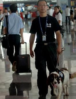 A policeman patrols with a police dog at terminal 3 of the Beijing Capital International Airport in Beijing, China, July 20, 2008.(Xinhua Photo)