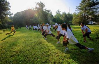 A Russian teacher leads students from southwest China's Sichuan Province to do morning exercises at a summer camp in Tuapse, a city on Russia's Black Sea coast, July 22, 2008. A group of 184 students from China's earthquake-hit province of Sichuan arrived here on July 19 for a three-week rehabilitation visit.(Xinhua Photo)