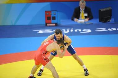 Buvaysa Saytiev of Russia (in blue) fights against Soslan Tigiev of Uzbekistan (Photo credit: Li Gang/Xinhua)