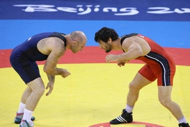 Yusup Abdusalomov (red) of Tajikistan fights against Revazi Mindorashvili of Georgia during their men's freestyle 84kg gold medal match of the Beijing 2008 Olympic Games Wrestling event in Beijing, China, Aug. 21, 2008. Revazi Mindorashvili beat Yusup Abdusalomov and grabbed the gold.(Xinhua/Lu Mingxiang)