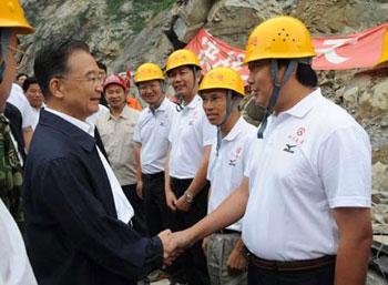 Chinese Premier Wen Jiabao (L) shakes hands with workers while visiting a road repair site near the epicenter, Yingxiu, southwest China's Sichuan Province, Sept. 2, 2008. (Xinhua Photo)