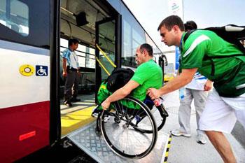 A Paralympic athlete rolls his wheelchair up a ramp with the help of a team staff member to get onto a bus in this picture taken on September 3, 2008.