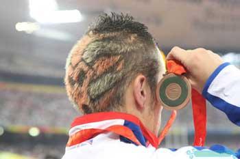 A&nbsp;British&nbsp;athlete,&nbsp;who&nbsp;wins&nbsp;the&nbsp;bronze&nbsp;in&nbsp;men's&nbsp;200m&nbsp;T44&nbsp;final,&nbsp;stands&nbsp;on&nbsp;the&nbsp;podium&nbsp;during&nbsp;the&nbsp;medal&nbsp;ceremony&nbsp;at&nbsp;the&nbsp;National&nbsp;Stadium,&nbsp;also&nbsp;known&nbsp;as&nbsp;the&nbsp;Bird's&nbsp;Nest,&nbsp;during&nbsp;the&nbsp;Beijing&nbsp;2008&nbsp;Paralympic&nbsp;Games&nbsp;September&nbsp;13,&nbsp;2008.&nbsp;His&nbsp;bizarre&nbsp;hairdo&nbsp;attracts&nbsp;much&nbsp;attention&nbsp;from&nbsp;media&nbsp;and&nbsp;spectators