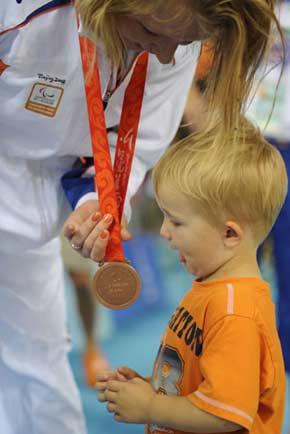 A&nbsp;sitting&nbsp;volleyball&nbsp;player&nbsp;of&nbsp;the&nbsp;Netherlands&nbsp;shares&nbsp;the&nbsp;victory&nbsp;with&nbsp;her&nbsp;little&nbsp;son&nbsp;after&nbsp;the&nbsp;medal&nbsp;ceremony,&nbsp;September&nbsp;14,&nbsp;2008.&nbsp;The&nbsp;Netherlands&nbsp;beats&nbsp;Slovenia&nbsp;to&nbsp;win&nbsp;the&nbsp;bronze&nbsp;in&nbsp;women’s&nbsp;sitting&nbsp;volleyball&nbsp;competition.[Xinhua]