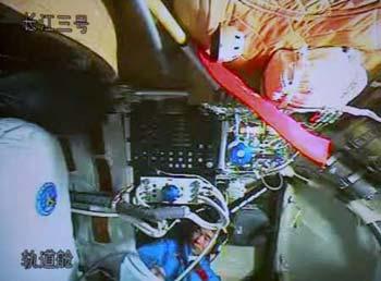 The video grab taken on Sept. 26, 2008 at the Beijing Space Command and Control Center in Beijing, China, shows Chinese astronaut Liu Boming unpacking and assembling the indigenous Feitian extra-vehicular activity (EVA) suit in Shenzhou-7. Astronauts aboard the Shenzhou-7 spacecraft, China's third manned spaceship, began to assemble the suit and test its obturation and functions at 10:20 a.m. Friday in preparation for the first spacewalk.  (Xinhua photo)