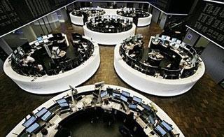 Stock brokers go about their business at the stock exchange in the central German city of Frankfurt/M. Wall Street and European stock markets soared Monday as investors cheered a massive bailout for US banking giant Citigroup and the prospect of more government money to ease the pain of recession.(AFP/DDP/Martin Oeser)