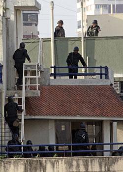 National Security Guard commandos prepare a rope to tie onto a railing on the terrace of Nariman Bhavan, in Mumbai, India, Friday, Nov. 28, 2008.(Xinhua/AFP Photo)