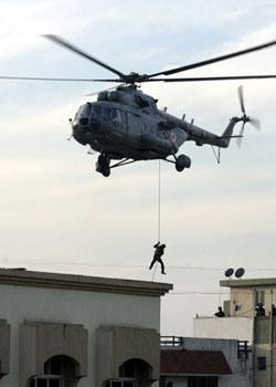 Indian commando comes down a rope to reach the top of Nariman House, a location under siege by suspected militants in Mumbai, India, Friday, Nov. 28, 2008.(Xinhua/Reuters Photo)