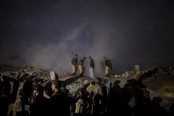 Pakistani police and rescue team members search for victims among the rubble of a collapsed building in Rawalpindi, Pakistan, Saturday, Dec.20, 2008. A building's collapse in the Pakistani city of Rawalpindi has injured at least eight people and at least 10 rescue workers are feared trapped in the rubble of the four-story shopping plaza, which collapsed Saturday several hours after it caught fire, a police official said.(AP Photo/Emilio Morenatti)