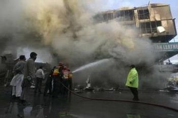 Fire fighters attempt to fight a fire after a shopping centre collapsed in Rawalpindi, December 20, 2008. A burning shopping centre collapsed in the Pakistani city of Rawalpindi on Saturday killing five people and trapping about 18, a city official said.REUTERS/Faisal Mahmood(PAKISTAN)