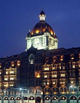 People walk past the Taj Mahal hotel in Mumbai. Two luxury hotels that were stormed by Islamist militants re-opened amid tight security in Mumbai Sunday, less than a month after devastating attacks that rocked India's financial and entertainment hub.(AFP/Sajjad Hussain)