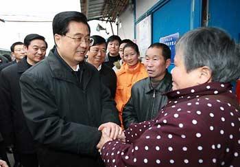Chinese President Hu Jintao (L Front) shakes hands with a woman as he visits residents of the Xingfu Community in Dujiangyan City, southwest China's Sichuan Province, Dec. 28, 2008. President Hu Jintao visited quake-hit Sichuan Province on Dec. 27-29, showing concern for survivors and inspecting reconstruction work. (Xinhua/Ju Peng)
