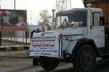 One of the trucks carrying humanitarian aid for the Gaza Strip drives past a Jordanian policeman at the King Hussein Bridge crossing December 29, 2008.REUTERS/Muhammad Hamed