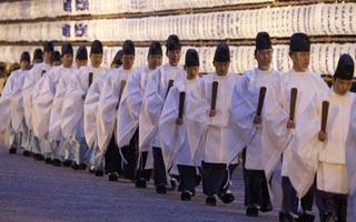 Shinto priests walk past lanterns after a Shinto ritual to usher in the New Year at the Meiji Shrine in Tokyo December 31, 2008. [Agencies]
