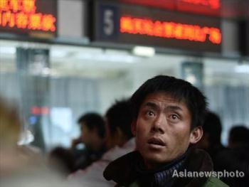 A man looks at an electronic schedule board at Beijing West Railway Station, January 1, 2009. [Asianewsphoto]