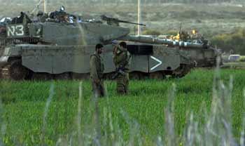 Two Israeli soldiers rest beside the tank in the Gaza Strip Jan.6, 2009. The Israeli army has said that it would hold fire in the Gaza Strip for three hours every day from Jan.7 to allow local residents to prepare basic supplies.(Xinhua/Tsafrir Abayov)
