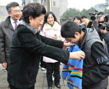 Chen Zhili (L), president of All-China Women's Federation and vice chairwoman of the Standing Committee of China's National People's Congress, selects a sweater for a student who lost parents during the devastating earthquake hitting Sichuan on May 12, 2008 at Tanghu High School in Dujiangyan City, southwest China's Sichuan Province, Jan. 6, 2009. An activity of sending sweaters to quake-hit areas, organized by All-China Women's Federation (ACWF) and China Children and Teenagers' Fund, has sent over 20,000 sweaters to students in quake-hit Sichuan Province. (Xinhua/He Junchang) 