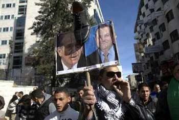 A&nbsp;Palestinian&nbsp;holds&nbsp;up&nbsp;a&nbsp;placard&nbsp;with&nbsp;pictures&nbsp;of&nbsp;Israel's&nbsp;Prime&nbsp;Minister&nbsp;Ehud&nbsp;Olmert&nbsp;(L)&nbsp;and&nbsp;Defence&nbsp;Minister&nbsp;Ehud&nbsp;Barak,&nbsp;during&nbsp;a&nbsp;protest&nbsp;in&nbsp;the&nbsp;West&nbsp;Bank&nbsp;city&nbsp;of&nbsp;Ramallah&nbsp;against&nbsp;Israel's&nbsp;offensive&nbsp;in&nbsp;Gaza,&nbsp;January&nbsp;5,&nbsp;2009.REUTERS/Fadi&nbsp;Arouri&nbsp;(WEST&nbsp;BANK)&nbsp;