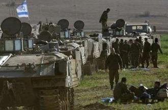 Israeli soldiers gather near armoured personnel carriers (APC) outside the northern Gaza Strip January 13, 2009.REUTERS/Gil Cohen Magen