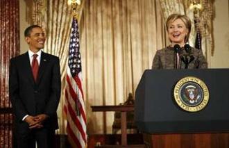 U.S. President Barack Obama smiles along with U.S. Secretary of State Hillary Clinton as she makes remarks at the State Department in Washington January 22, 2009. REUTERS/Kevin Lamarque