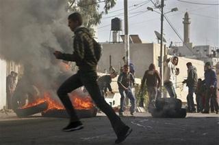 Palestinian demonstrators clash with Israeli soldiers, not seen, during a demonstration against Israel's military operation in Gaza, in the West Bank village of Azzun, near Qalqilya, Sunday, Dec. 28, 2008. More than 280 Palestinians, most of them Hamas police, were killed and hundreds more wounded since Israel's campaign to quash rocket barrages from Gaza began midday Saturday.(AP Photo/Nasser Ishtayeh)