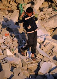 A Palestinian boy searches for belongings in the rubbles of a house in Jibaliya, northern Gaza Strip, Jan. 27, 2009. According to the survey conducted by the Palestinian Central Bureau of Statistics and the UN coordination office for Human Rights, more than 4,000 houses were destroyed, 17,000 others damaged and 90,000 people became homeless, due to the Israeli operation of Cast Lead.(Xinhua/Yin Bogu)