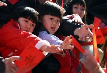 Local Chinese children receive Spring Festival couplets during a parade celebrating the Chinese Lunar New Year, the Year of the Ox, on February 1, 2009 at the Chinatown in New York.(Xinhua/Hou Jun)