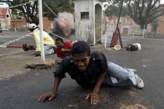 A&nbsp;man&nbsp;tries&nbsp;to&nbsp;run&nbsp;from&nbsp;gun&nbsp;shots&nbsp;near&nbsp;Madagascar&nbsp;President&nbsp;Marc&nbsp;Ravalomanana's&nbsp;offices&nbsp;in&nbsp;Antananarivo.(AFP/Walter&nbsp;Astrada)