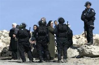 Israeli police guard and a Palestinian family watch the demolition of their house which was built without permission in Isawiyya, on February 4, 2009. Palestinian president Mahmud Abbas on Monday called on Israel to halt settlement expansion and said he would not start from scratch in peace talks with the Jewish state's next government.(AFP/File/Ahmad Gharabli)