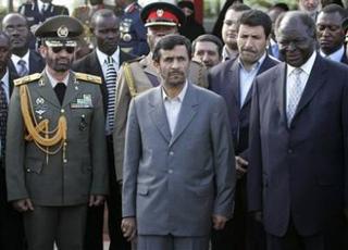 Kenyan President Mwai Kibaki , right, and Iranian President Mahmoud Ahmadinejad, center, look at traditional dancers, not seen, as the Iranian president arrived at Jomo Kenyatta airport in Nairobi, at the start of a two day official visit Tuesday Feb. 24, 2009.(AP Photo/Karel Prinsloo)