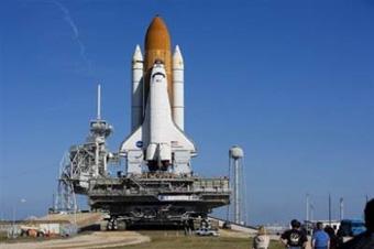 NASA workers watch as the space shuttle Discovery is moved to the launch site at the Kennedy Space Center in January.(AFP/Getty Images/File/Matt Stroshane)